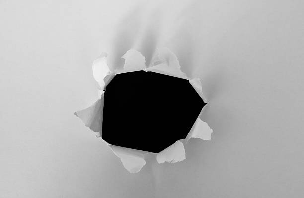 istock Torn white paper hole reveals black background 2235567558