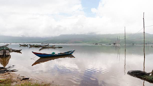 istock Serene lakeside with colorful boats and calm reflections. 2235569597