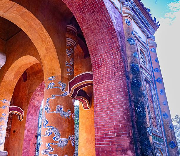 Intricate architectural details of a historic archway with vibrant colors and dragon motifs in Hue, Vietnam.