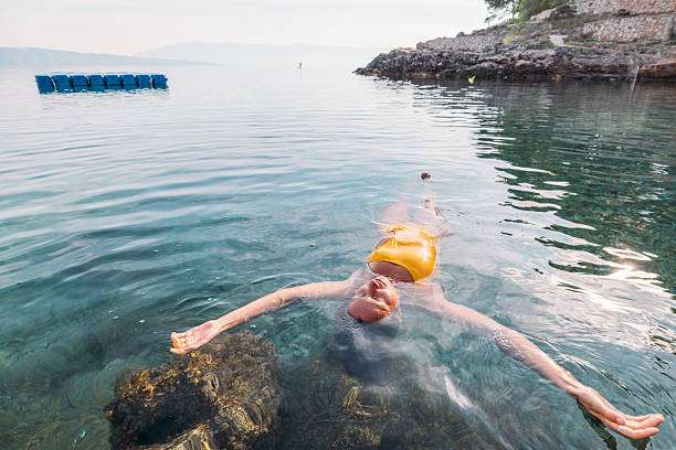 istock Woman Floating Relaxed in Clear Calm Water 2235569902
