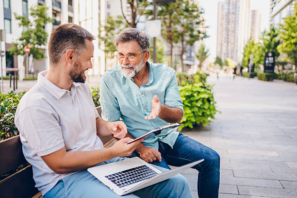 istock Two businessmen sitting and talking outside 2235570542