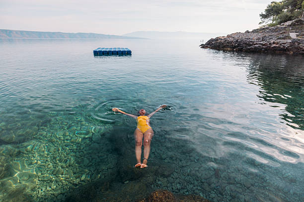istock Woman Floating Relaxed in Clear Calm Water 2235572449