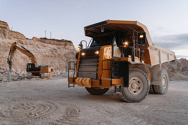 istock Large dumper truck and excavator working in a quarry at sunset 2235574384