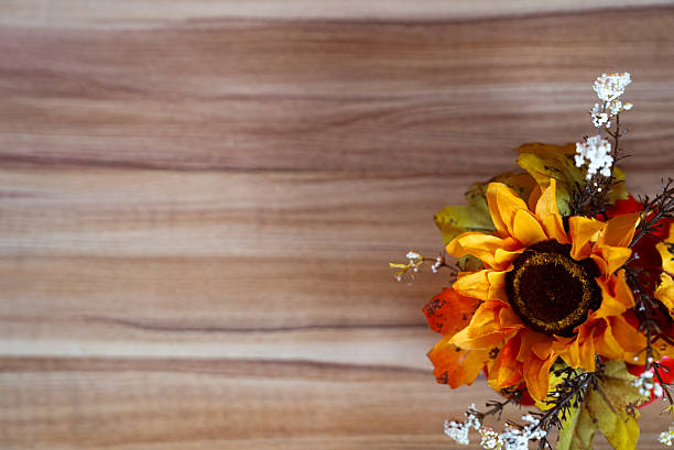 Bright autumn sunflower with seasonal decor on rustic wooden texture background. Perfect for fall holidays and Thanksgiving.