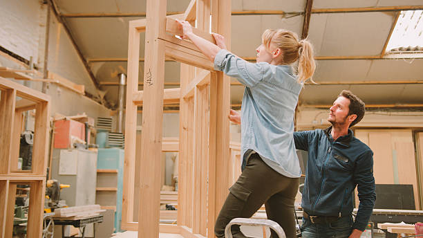 istock Male And Female Carpenters Working In Woodwork Workshop Making Window Frame Together 2235577423