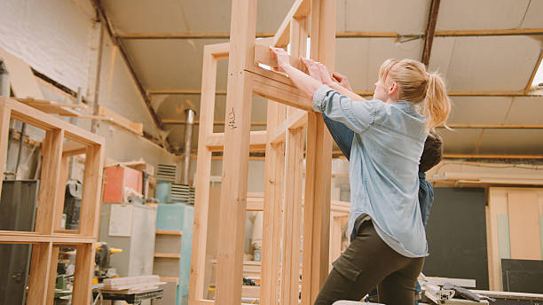 istock Male And Female Carpenters Working In Woodwork Workshop Making Window Frame Together 2235577509