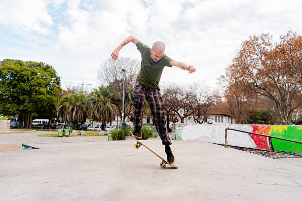 istock Mid adult man doing skateboard tricks at public park 2235580320