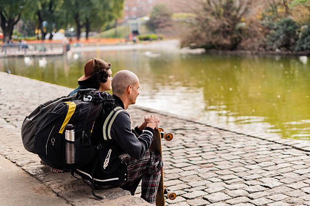 Skater friends talking by the lake in the park