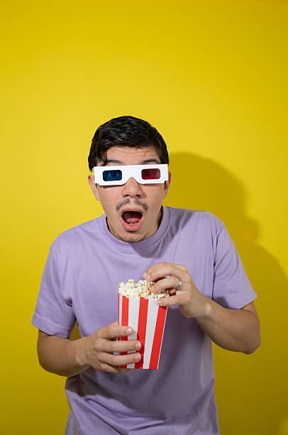 istock Man with 3D glasses surprised with mouth open while holding popcorn 2235580961