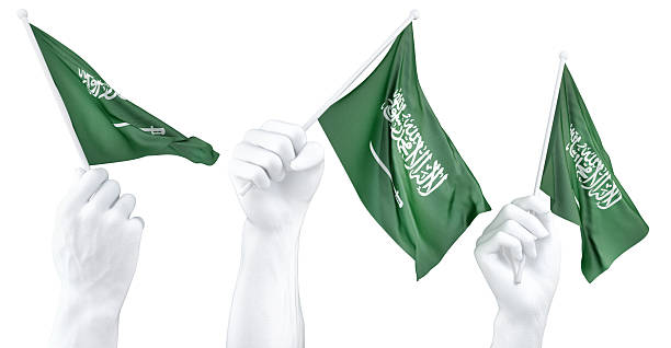 Hand holding flag of Saudi Arabia. Isolated 3d Rendering.