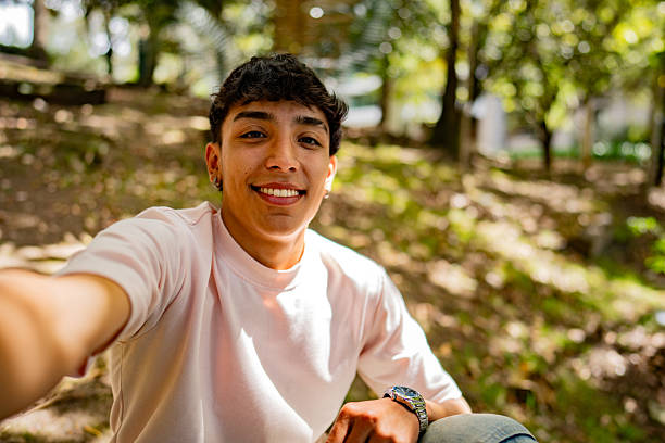 istock Young man taking a selfie on a public park - camera point of view 2235587055
