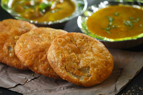 Delicious crispy kachoris served with spicy aloo sabzi and flavorful chole, a popular North Indian street food combination.