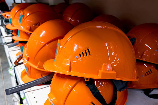istock Bright orange safety helmets arranged neatly on a shelf in a construction site, ready for workers to use during building projects and ensuring worker safety on site 2235591149
