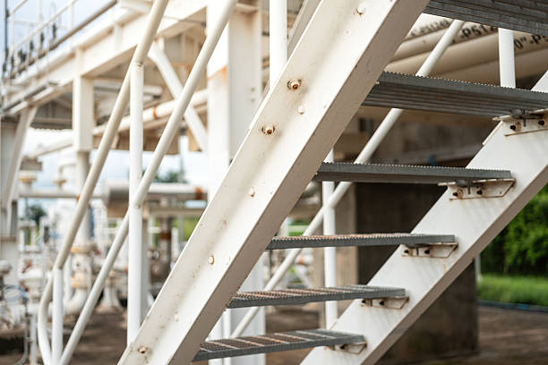 An overpass walkway across the production pipeline at the petrochemical and refinery plant. Industrial work place, close-up and selective focus.