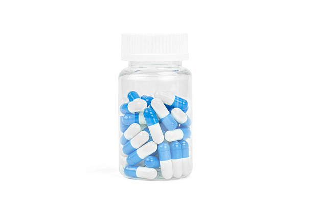 istock Plastic pill bottle filled with blue and white capsules, isolated on white background with clipping path. 2235593699