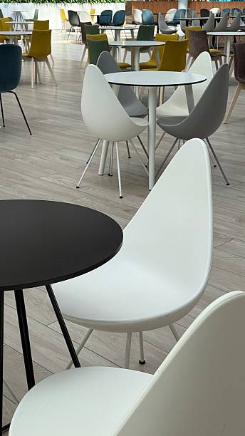 istock Empty modern cafeteria with stylish chairs and round tables, ideal for backdrop or copy space 2235594137