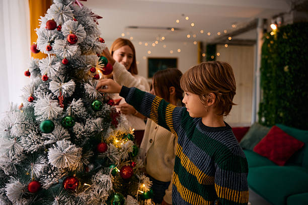 istock Family decorating Christmas tree together at home 2235594873
