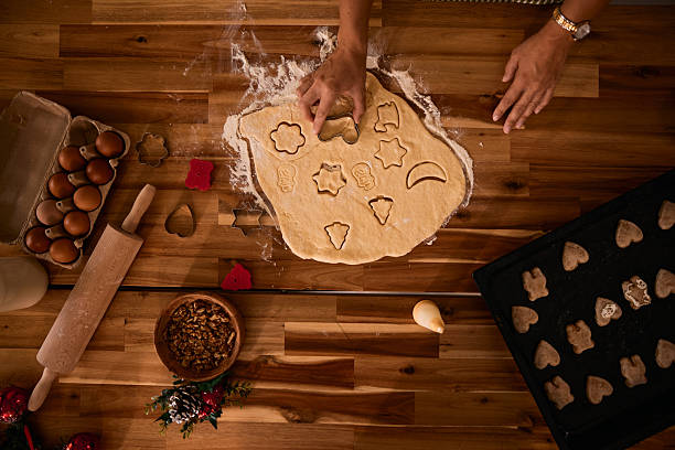 istock Woman making christmas cookies using cookie cutters 2235596137