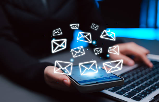 istock Email communication and digital messaging concept. Woman using smartphone with envelope icons, symbolizing online correspondence, email marketing, new email notification, newsletter, reply mail, 2235596188