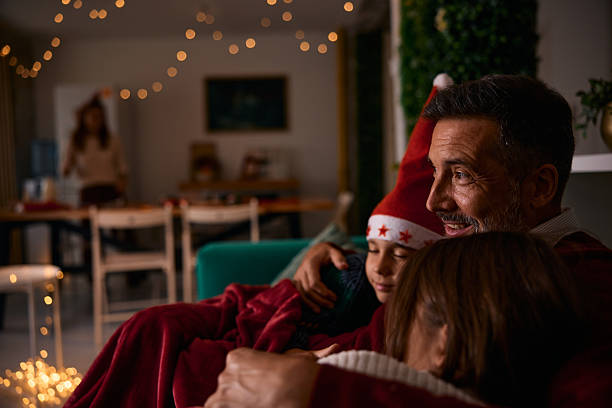 istock Father embracing children on sofa during Christmas holidays 2235596968