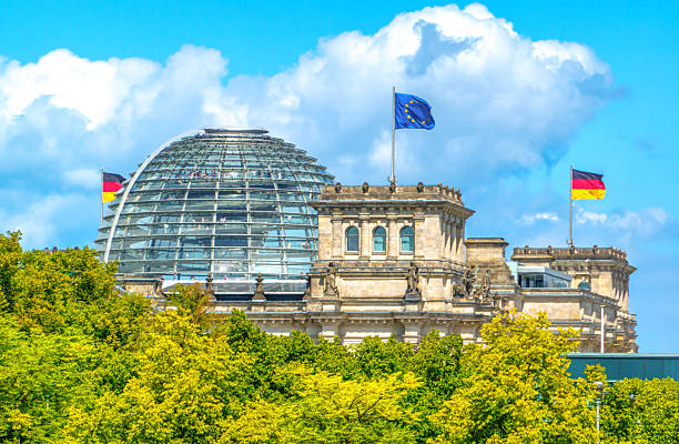 Berlin, Germany - June 21, 2014: Reichstag glass dome construction above German parliament (Bundestag). Construction of cupola (designed by architect Norman Foster) was finished in 1999, the seat of Bundestag was transfered here also same year. People visiting the monument on the rooftop.