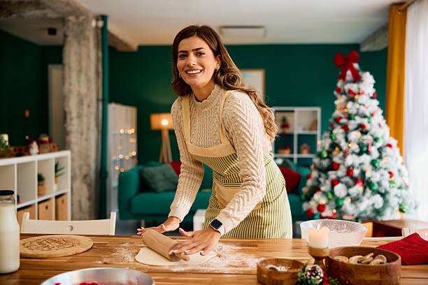 istock Woman making christmas cookies in her decorated kitchen 2235597641