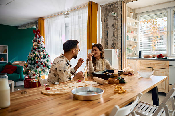 istock Young couple tasting Christmas cookies in the kitchen 2235597938