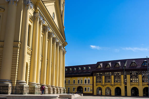 Debrecen, Hungary July 30, 2025  Peaceful square with neoclassical columns, timber-framed building, benches, trees, and relaxed urban atmosphere.