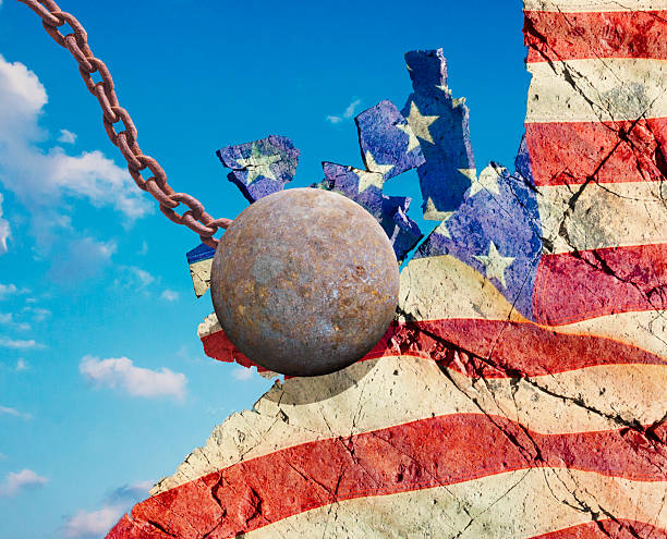 Conceptual image of wrecking ball breaking American flag