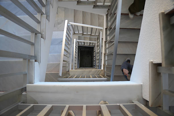 A stunning architectural photograph featuring a geometric staircase with unique, modern design. The stairs lead upward in a mesmerizing pattern, creating a sense of depth and intrigue. Soft natural light illuminates the minimalist interior, emphasizing the clean lines and striking angles of the staircase. The image captures a moment of urban exploration, inviting the viewer to ascend the stairs and discover what lies beyond.