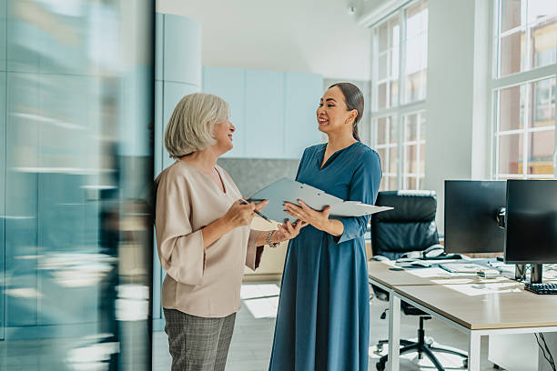 istock Professional women engaging in productive discussion during office meeting 2235610096