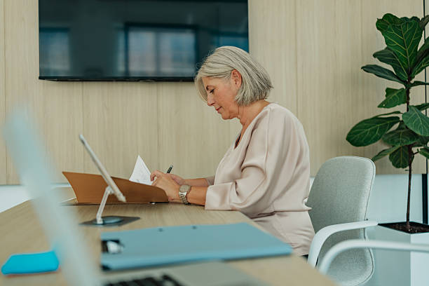 istock Senior woman working in a modern office, displaying elegance and confidence while managing her business tasks 2235610232
