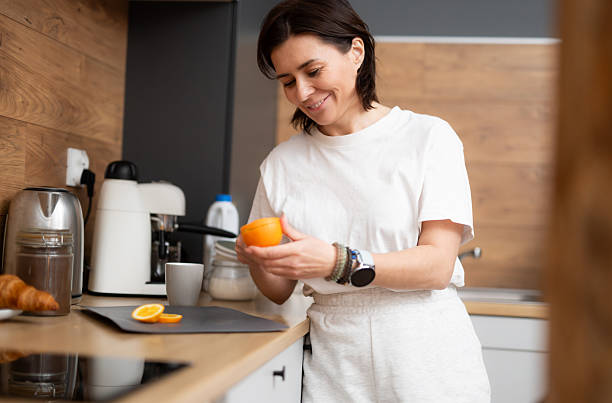 istock Happy Girl Cutting A Fresh Orange For Breakfast 2235610356