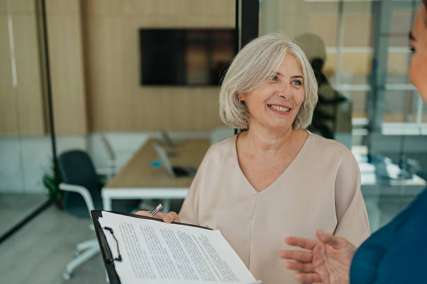 istock Senior and mature women engage in productive discussion in a modern office setting 2235611431