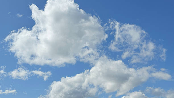 White fluffy clouds in blue sky on sunny day, scattered cumulus cloud formations with bright natural light, suitable for backgrounds, weather concepts, and nature-themed designs