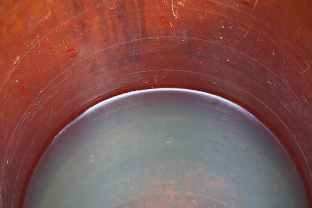 Close Up of Rusty Industrial Metal Drum Interior With Little Amount of Water