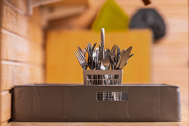 Cutlery drying in plastic basket after wash.