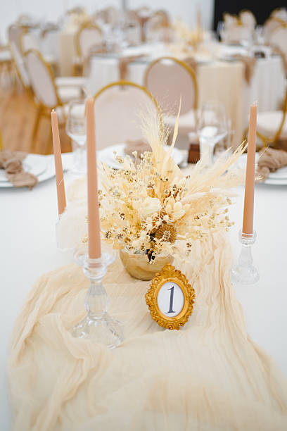 istock Wedding table setting with dried flower composition, candles and number in golden frame. 2235612494