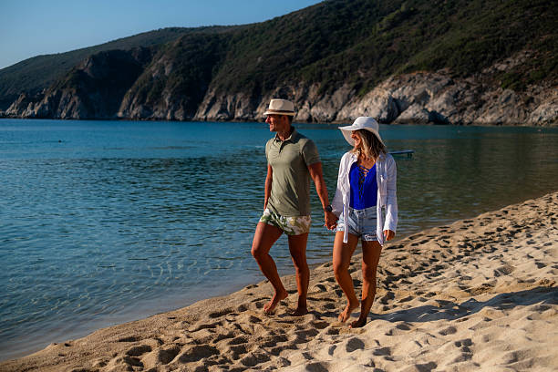 istock Happy couple walking on the beach, enjoying summer vacation 2235613059
