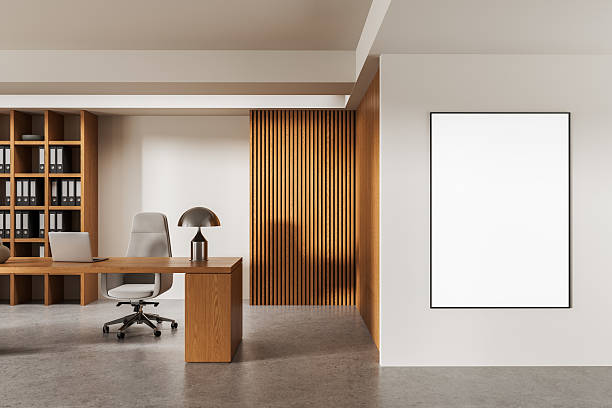 istock Modern office interior with wooden desk, bookshelf, and vertical slat wall featuring a blank poster mockup on white wall. 3D Rendering. 3D Rendering 2235614855