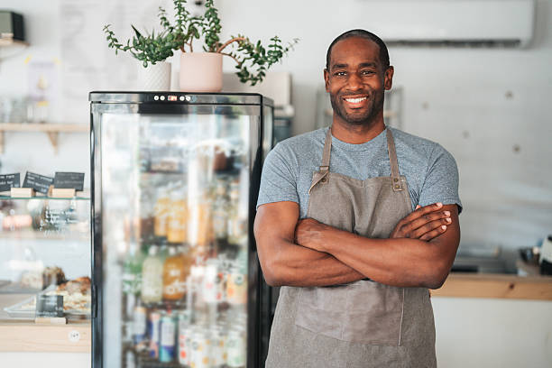 istock Cheerful young cafe owner wearing apron and smiling at camera 2235615607