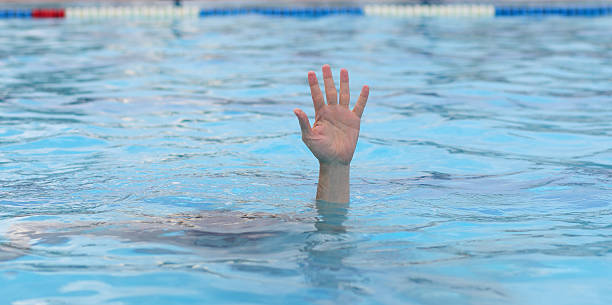 istock hand of a boy asking for help while drowning under the pool water 2235618082
