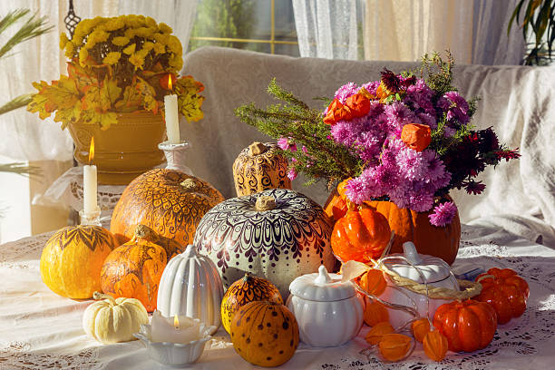 Thanksgiving day, a festive autumn table decorated with various pumpkins, candles and bright floral arrangements. Warm sunshine and a colorful Thanksgiving day atmosphere.