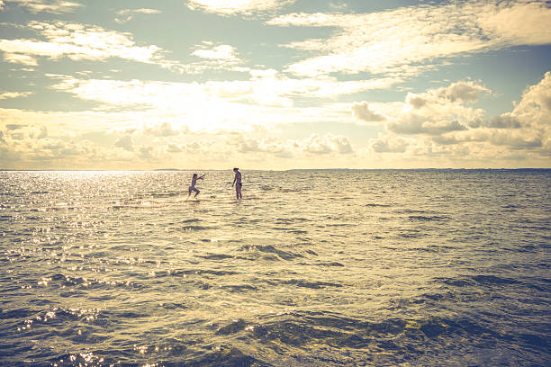 Mother and daughter playing, swimming and bathing together on Kulhuse Beach in the Fjord Isefjorden in Denmark. This is a shallow sandy beach with crystal clear and clean water ideal for summer vacation with kids
