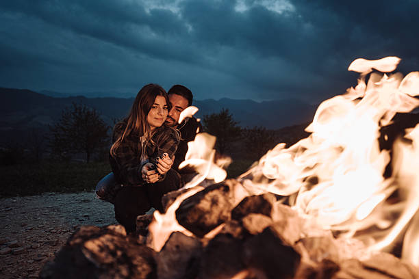istock lovely passionate couple in front at the fire camping 2235621084