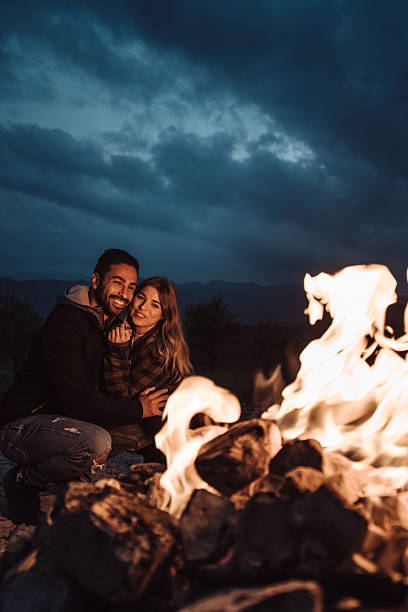 istock lovely passionate couple in front at the fire camping 2235621122