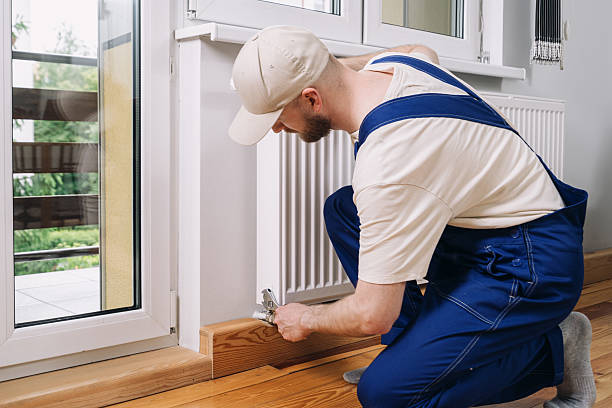 istock Man performing maintenance on a radiator in a modern apartment 2235623088