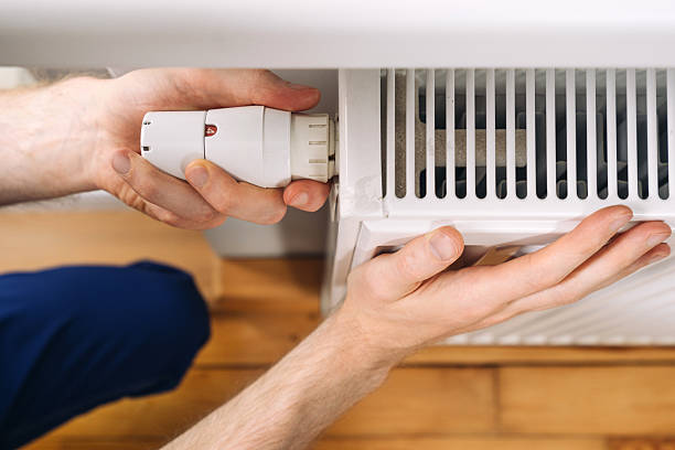 istock Home heating radiator maintenance with a plumber installing a new component 2235623094