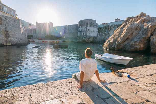 istock Man Relaxing by Historic Harbor at Sunset 2235625921