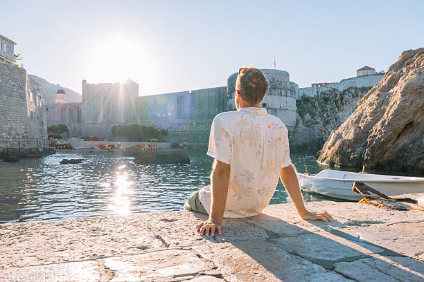 istock Man Relaxing by Historic Harbor at Sunset 2235625939